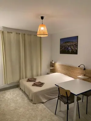 a bedroom with a bed and a table and a chandelier at Joli studio, quartier du port in Nice