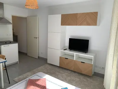 a living room with a tv on a white cabinet at Joli studio, quartier du port in Nice