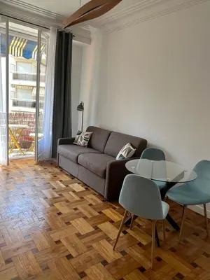 a living room with a couch and a table and chairs at Appartement Rex in Nice