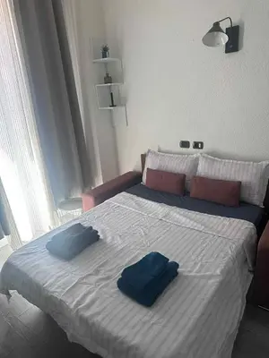 a bedroom with a bed with two blue pillows on it at joli studio en face de la gare in Nice
