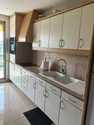 a kitchen with white cabinets and two sinks at Elegant apartment a Nice, Sea View in Nice