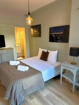 a bedroom with a large bed and a table at Cocon Provençale à 5 min de la mer in Nice