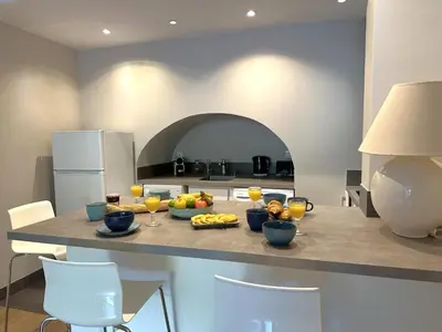 a kitchen with a table with fruit and drinks on it at Cocon Provençale à 5 min de la mer in Nice