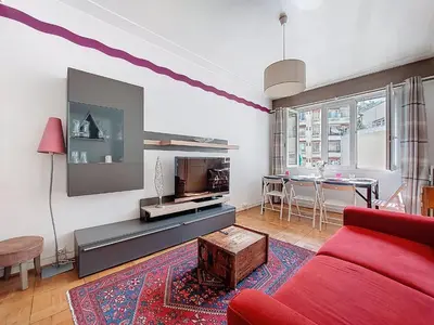 a living room with a red couch and a tv at Apartment Daphné by Interhome in Nice