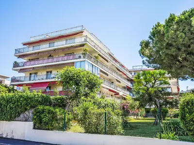 an apartment building with trees in front of it at Apartment Le Persépolis by Interhome in Cagnes-sur-Mer