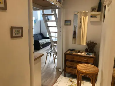 a living room with a staircase and a table and chairs at Agréable studio cœur de Nice in Nice