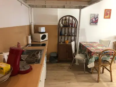 a kitchen with a stove and a microwave and a table at Agréable studio cœur de Nice in Nice