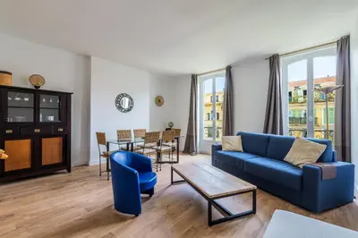 a living room with a blue couch and a table at Elegant et lumineux 3 pieces Avenue Jean Medecin in Nice