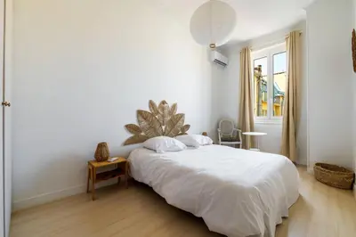 a white bedroom with a bed and a window at Elegant et lumineux 3 pieces Avenue Jean Medecin in Nice