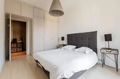 a white bedroom with a large bed with white sheets at Elegant et lumineux 3 pieces Avenue Jean Medecin in Nice
