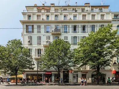 a white building with trees in front of it at Elegant et lumineux 3 pieces Avenue Jean Medecin in Nice