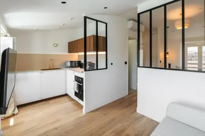 a kitchen with white cabinets and glass walls at Magnifique studio boulevard gambetta - A in Nice