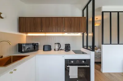 a kitchen with white cabinets and a microwave at Magnifique studio boulevard gambetta - A in Nice