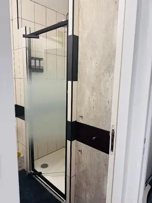 a glass door to a shower in a bathroom at LE CARRAS - Proche de aéroport , Plage à pied - Promenade des anglais in Nice