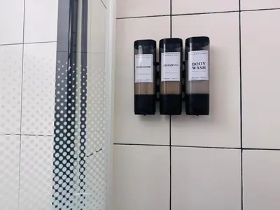 two bottles ofodorizers on the wall of a bathroom at LE CARRAS - Proche de aéroport , Plage à pied - Promenade des anglais in Nice