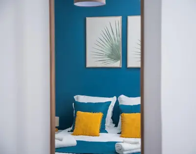 a room with blue walls and yellow pillows at Rêve Bleu de Nice - Terrace - Beach & Tram 5 min in Nice