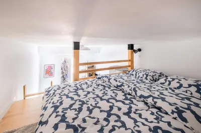 a bedroom with a bed with a blue and white comforter at The cozy corner of Amelie in Nice