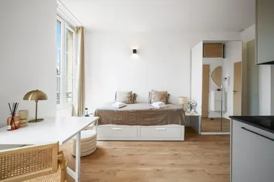 a white room with a bed and a kitchen at Soleil Sucré - Splendid cocoon near Jean Médecin in Nice