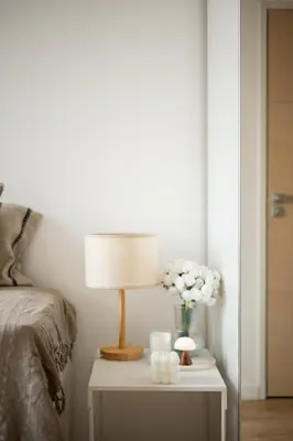 a bedside table with a lamp and flowers on it at Soleil Sucré - Splendid cocoon near Jean Médecin in Nice