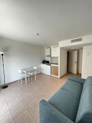 a bed in a room with a table and chairs at Studio bord de plage à Nice in Nice