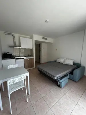 a bedroom with a bed and a kitchen with a table at Studio bord de plage à Nice in Nice