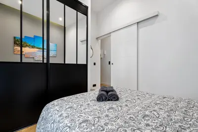 a bedroom with a bed and a black door at Nice Renting - VERDUN - Designer Cocoon Massena Calm Air Conditioning in Nice