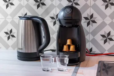 a black coffee maker and two glasses on a table at Nice Renting - VERDUN - Designer Cocoon Massena Calm Air Conditioning in Nice