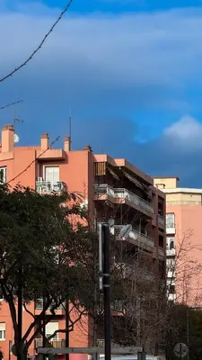 a tall brick building with a balcony in front of it at La Vague Douce in Nice