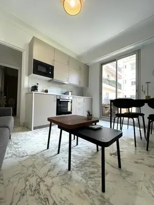 a living room with a table and a kitchen at Super studio Carré d'Or-2 people-Nice in Nice