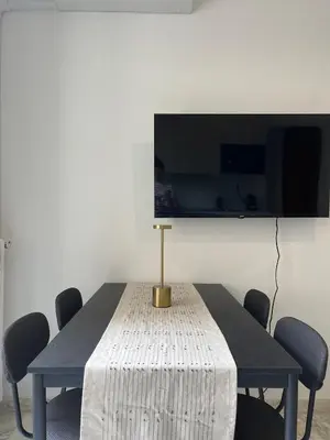 a dining room table with chairs and a tv at Super studio Carré d'Or-2 people-Nice in Nice