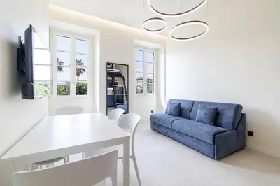 a living room with a blue couch and a table at PLACE MASSENA Coulée Verte in Nice