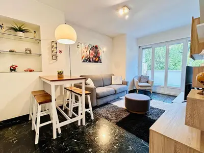 a living room with a couch and a table at Azure Horizons Seaside Escape in Beaulieu-sur-Mer