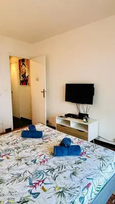 a bedroom with a large bed with two blue pillows on it at Azure Horizons Seaside Escape in Beaulieu-sur-Mer