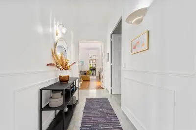 a hallway with white walls and a black table at Sumptuous Art Deco Apartment - 6 People in Nice