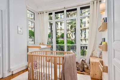a room with a crib and large windows at Sumptuous Art Deco Apartment - 6 People in Nice