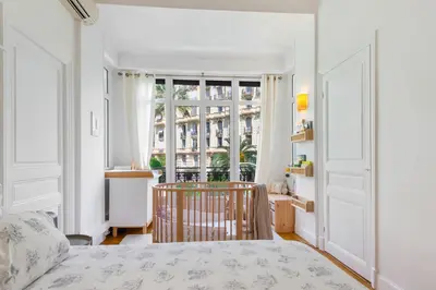 a bedroom with a bed and a large window at Sumptuous Art Deco Apartment - 6 People in Nice