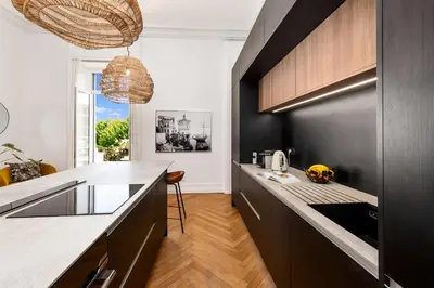 a kitchen with black cabinets and a counter top at Sumptuous Art Deco Apartment - 6 People in Nice