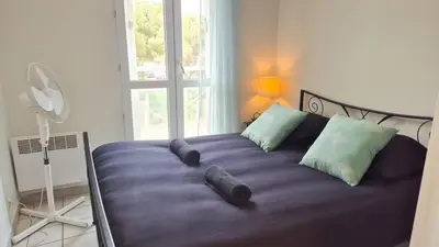 a large purple bed with pillows and a window at Appartement 2P, balcon, parking proche mer in Nice