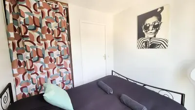 a bedroom with a bed and a picture on the wall at Appartement 2P, balcon, parking proche mer in Nice