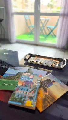 a table with a cell phone and some books at Appartement 2P, balcon, parking proche mer in Nice