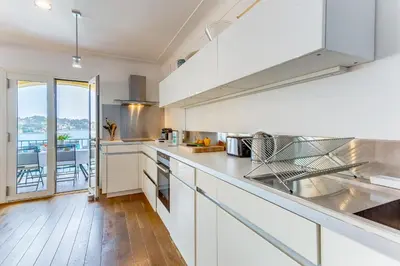a kitchen with white cabinets and a large window at EDEN VIEW AP4469 by Riviera Holiday Homes in Villefranche-sur-Mer