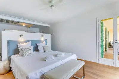 a white bedroom with a large bed with white sheets at EDEN VIEW AP4469 by Riviera Holiday Homes in Villefranche-sur-Mer