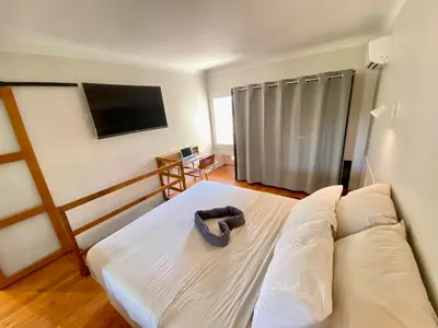 a living room with a couch and a flat screen tv at Duplex 1 min de la plage in Beaulieu-sur-Mer
