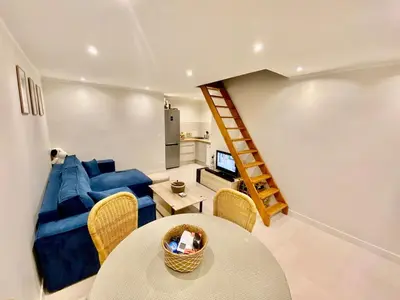 a living room with a blue couch and a table at Duplex 1 min de la plage in Beaulieu-sur-Mer