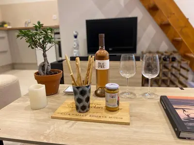 a table with a bottle of wine and two wine glasses at Duplex 1 min de la plage in Beaulieu-sur-Mer
