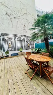 a patio with a table and two chairs and a palm tree at Appartement LOFT in Nice