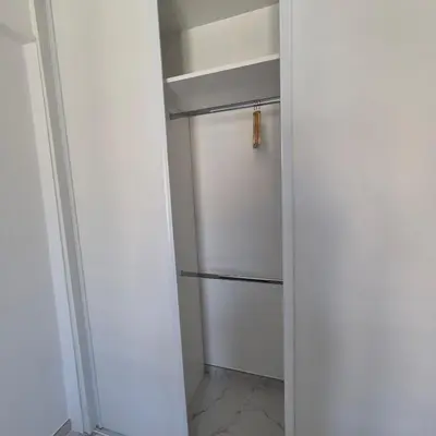 a walk in closet with a white refrigerator at Bahri House in Nice