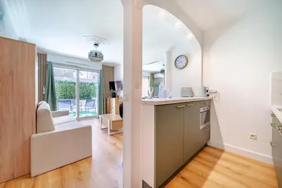 a kitchen with an archway leading into a living room at Studio Jardin Parking et Clim in Nice