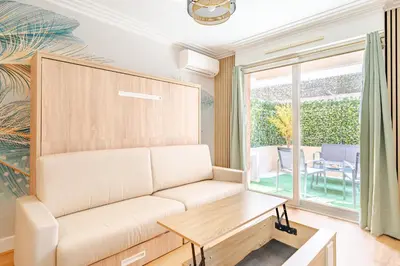 a living room with a couch and a table at Studio Jardin Parking et Clim in Nice