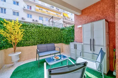a balcony with a table and chairs and a building at Studio Jardin Parking et Clim in Nice